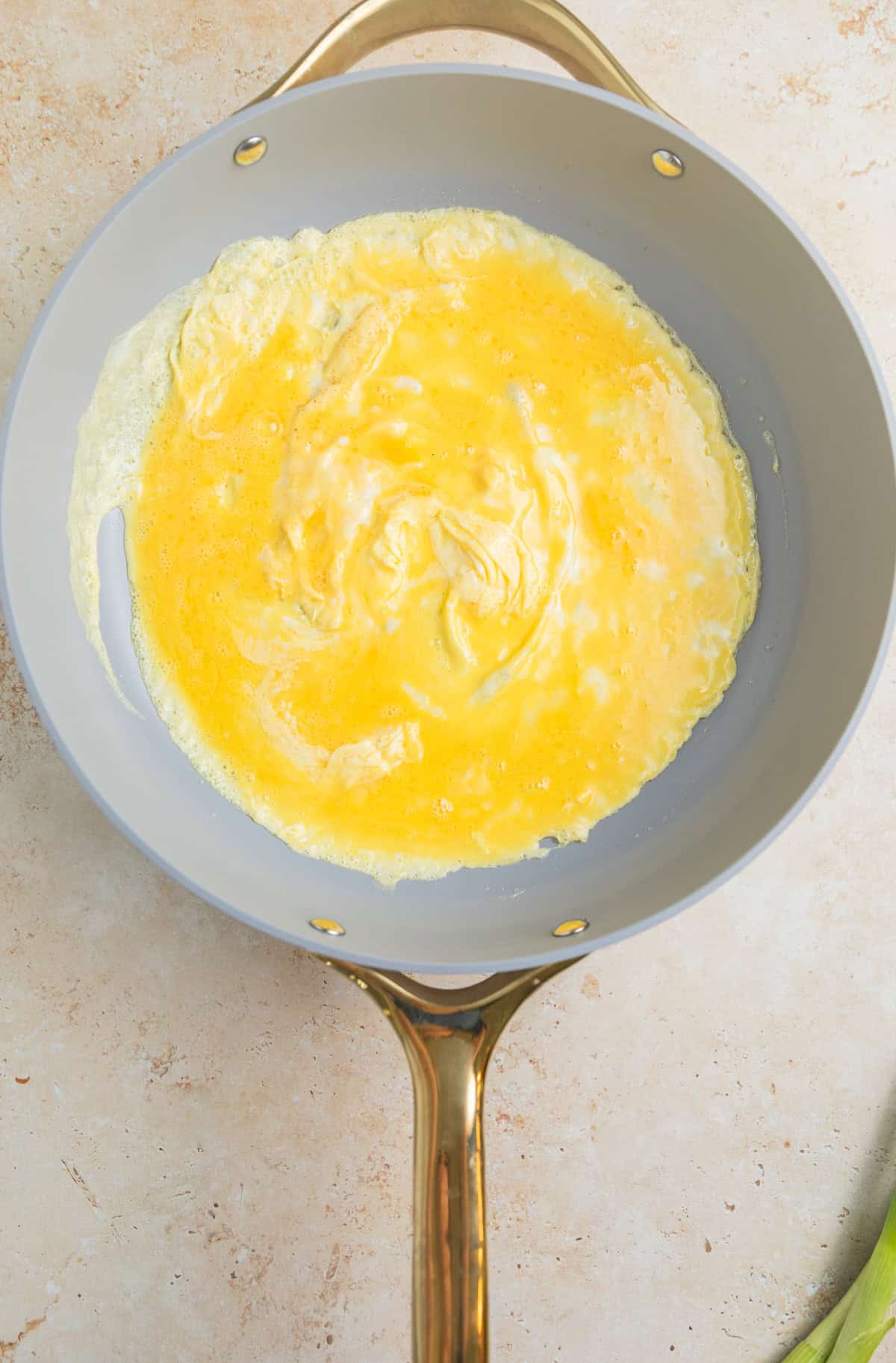 Scrambling eggs in large skillet.