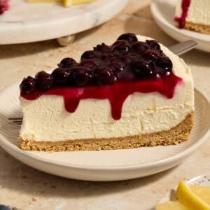 Lemon blueberry cheesecake slice on plate.