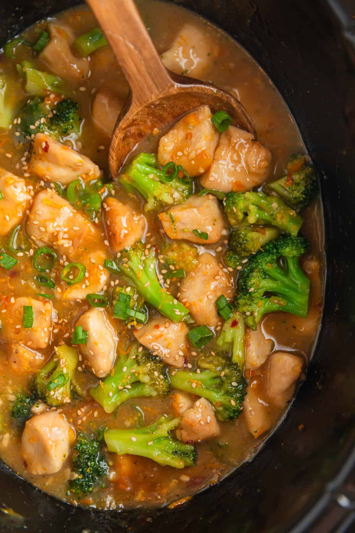 Overhead view of crockpot with chicken and broccoli in orange sauce.