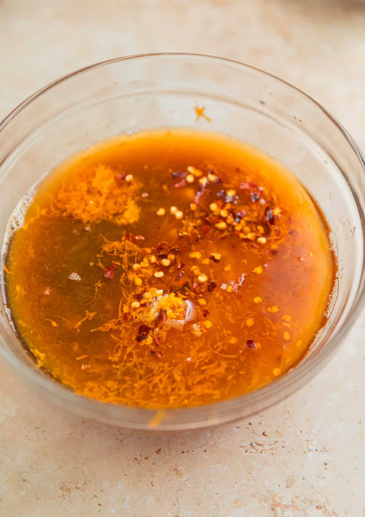 Ingredients for orange chicken sauce in glass bowl.