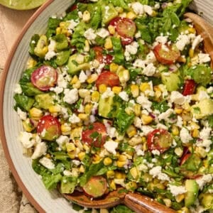 Salad with grilled corn, romaine, avocado, tomato in bowl.