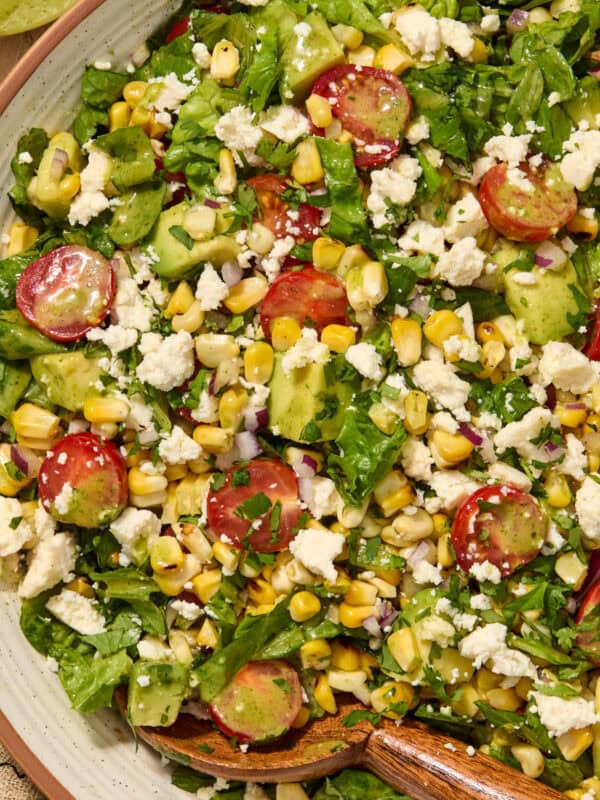 Salad with grilled corn, romaine, avocado, tomato in bowl.