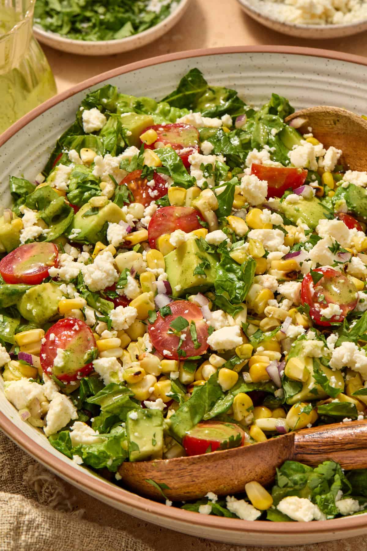 Chopped salad with grilled corn, tomato and other ingredients in salad bowl.