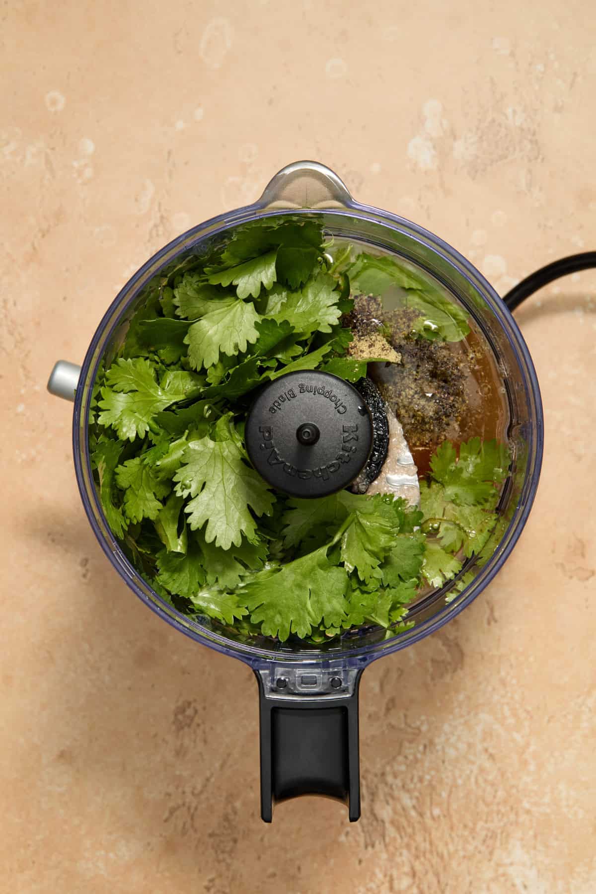 Food processor with cilantro lime ingredients for dressing before processed.