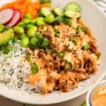 Rice bowl with ground turkey, bang bang sauce, cucumber, carrots and other ingredients.