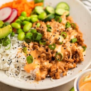 Rice bowl with ground turkey, bang bang sauce, cucumber, carrots and other ingredients.