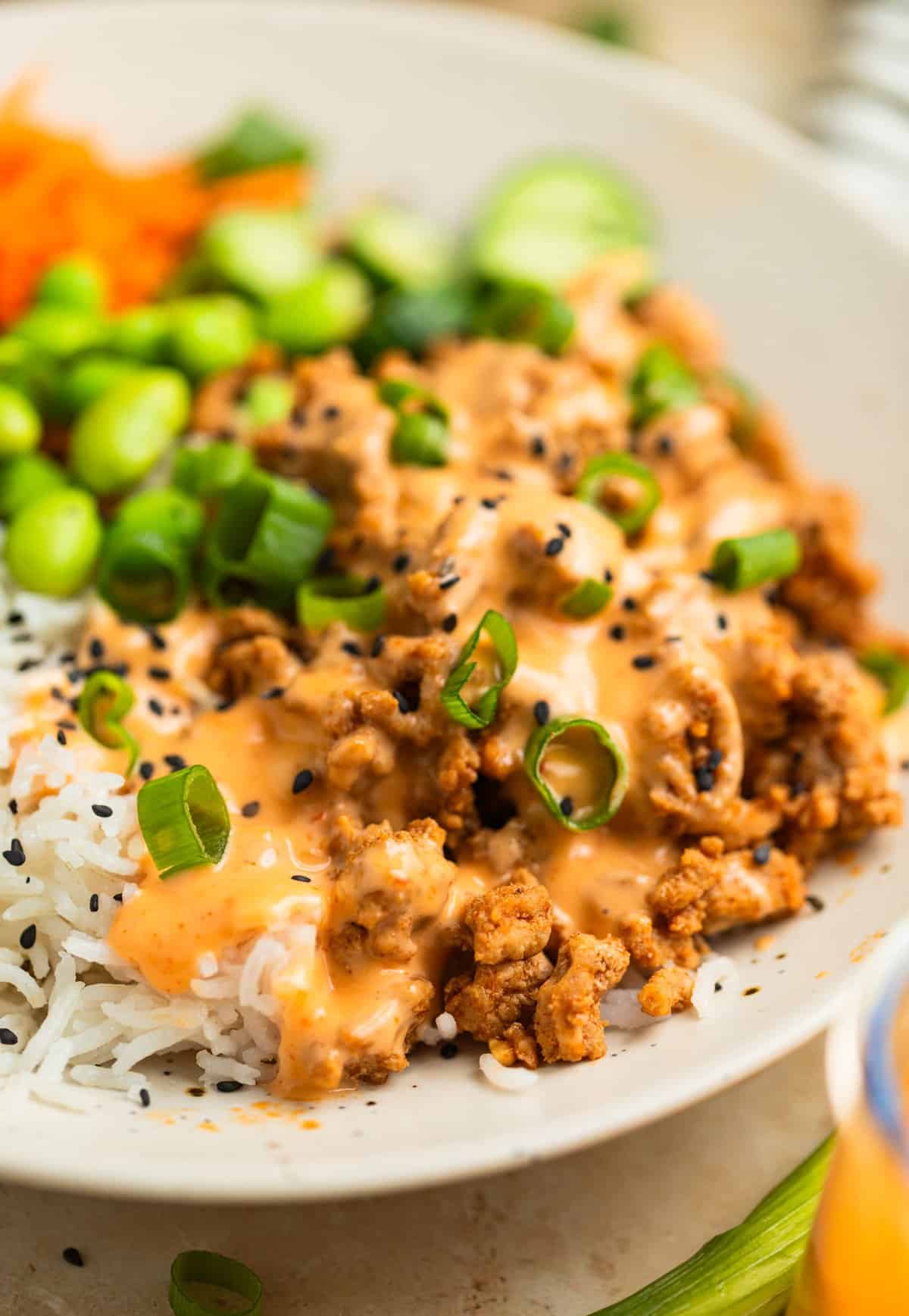 Ground turkey rice bowls topped with bang bang sauce.