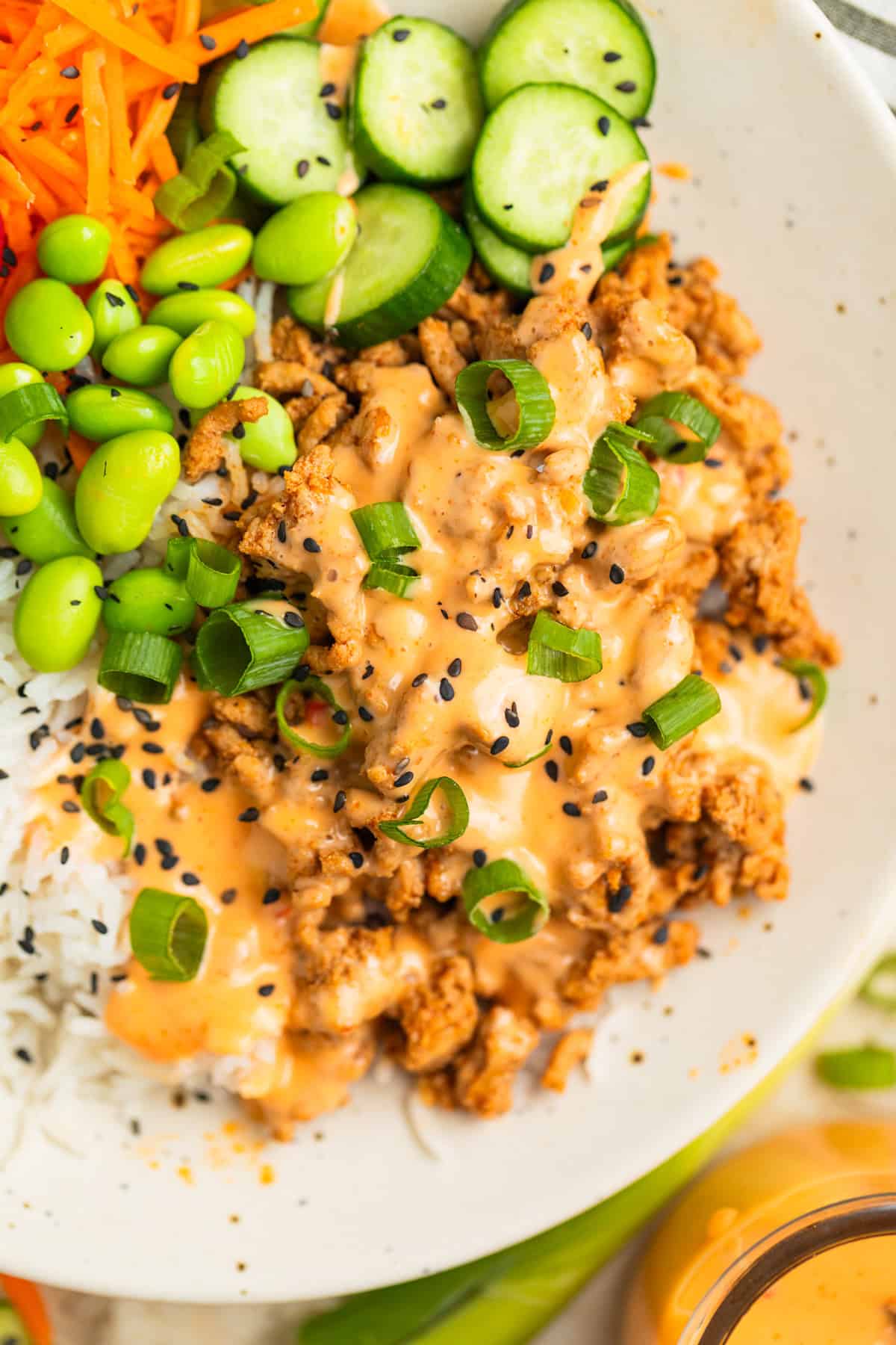 Ground turkey rice bowl with bang bang sauce poured over the turkey.