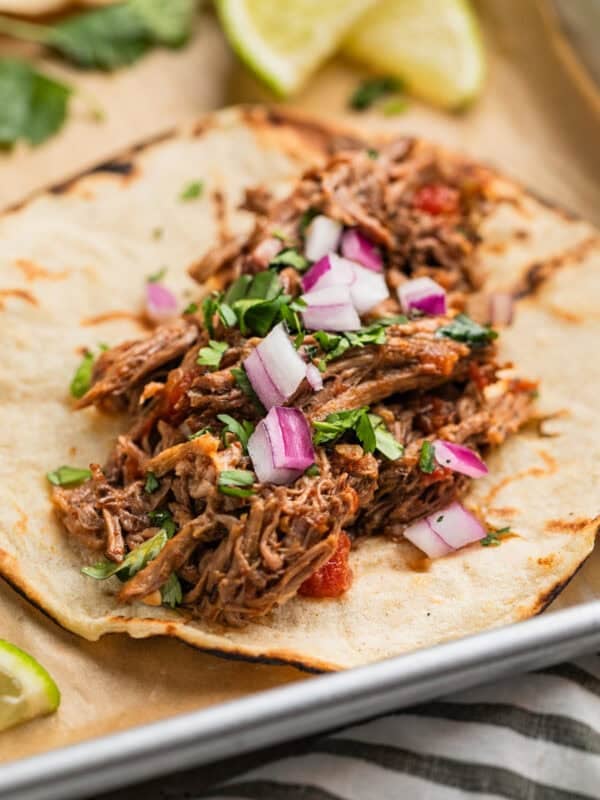 Shredded beef taco topped with cilantro and red onion.