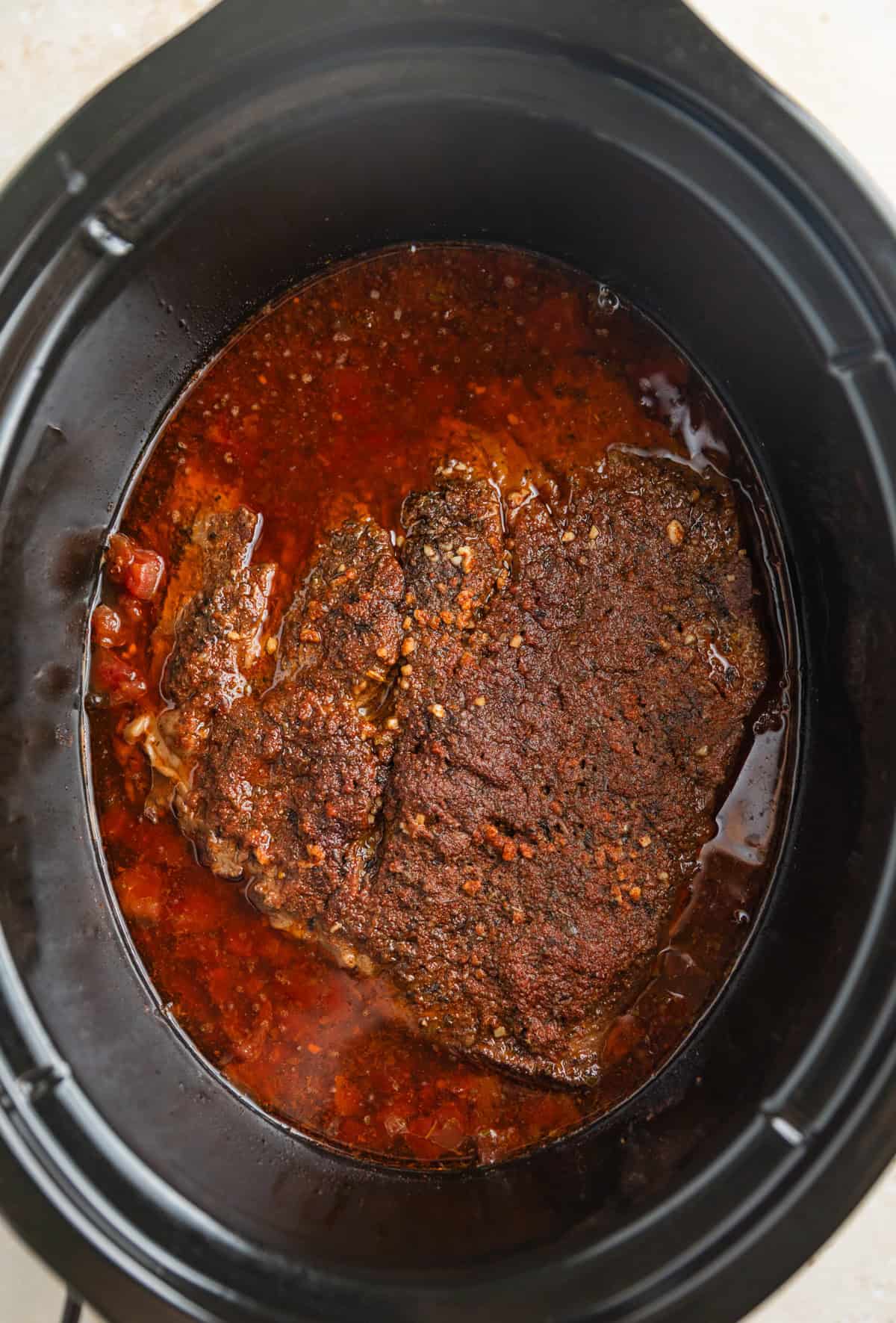 Slow cooker beef cooked in juices in crockpot.