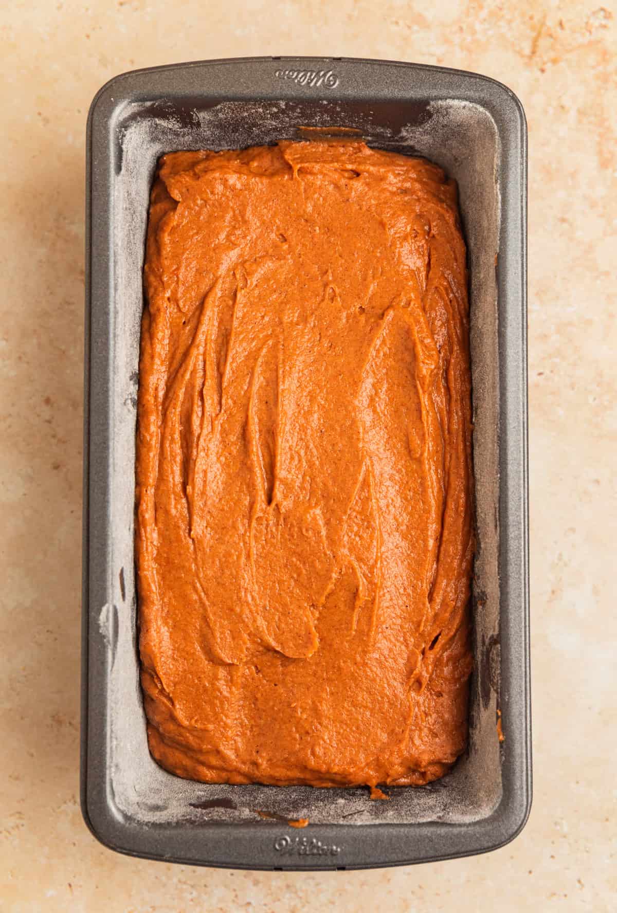 Pumpkin bread batter in greased and floured loaf pan.