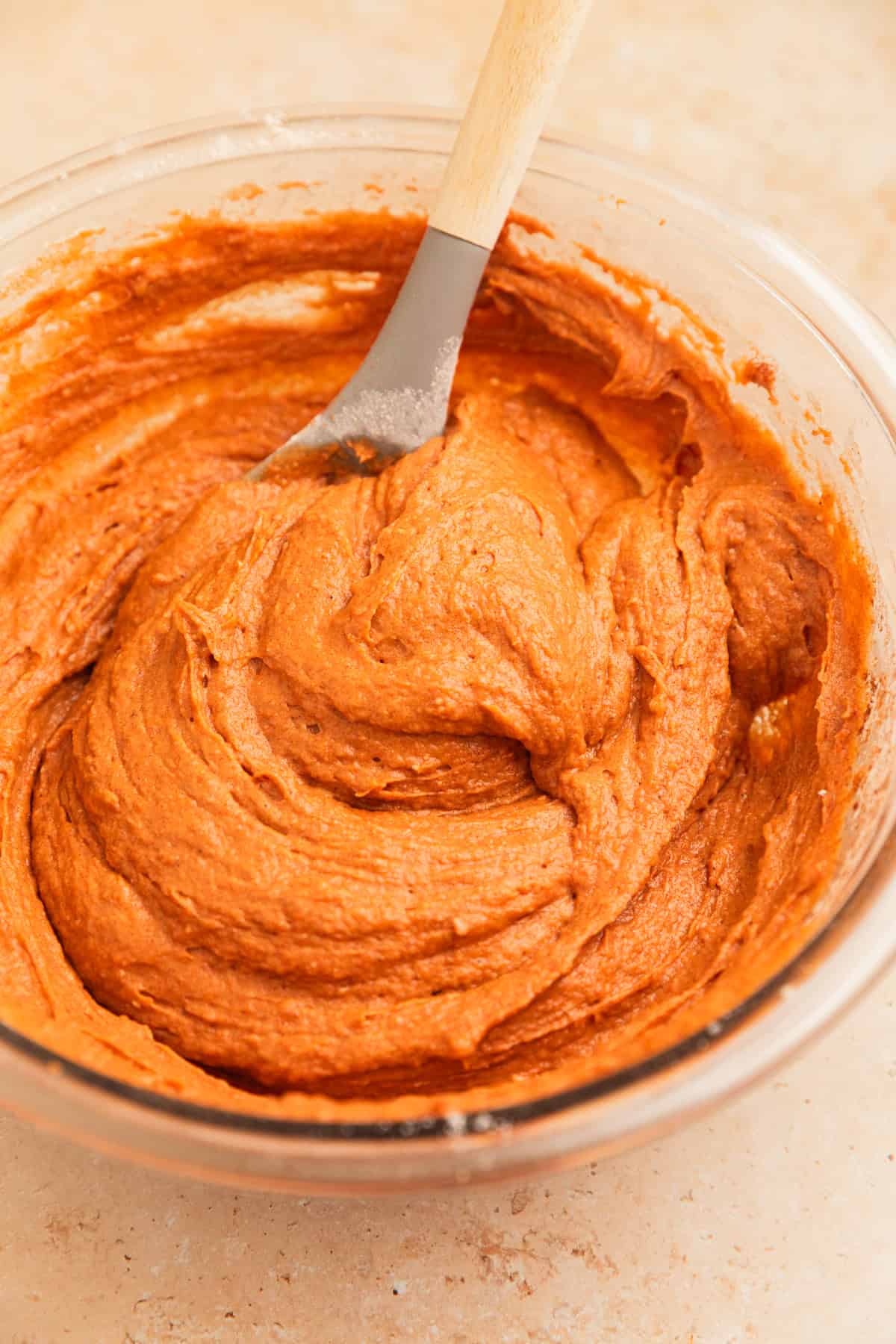 Cake mix pumpkin bread mixture in glass mixing bowl with spoon.