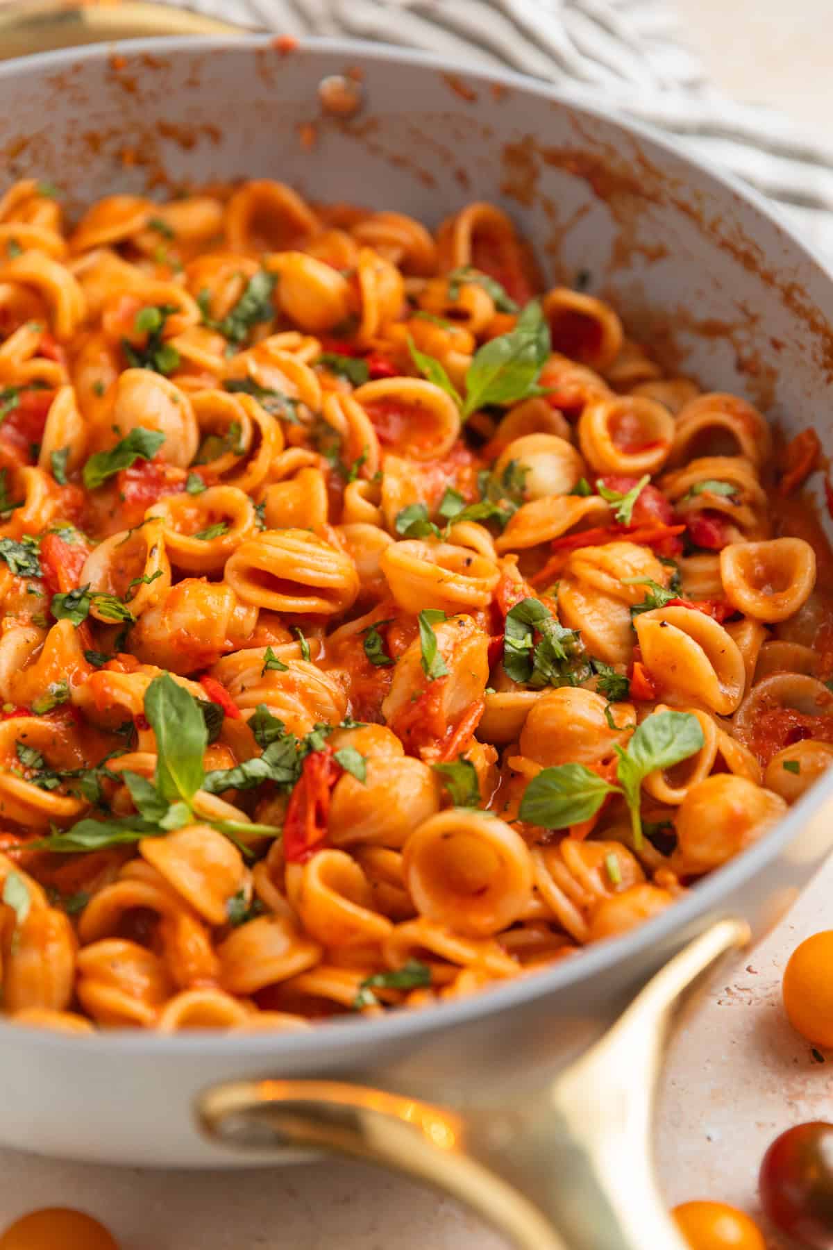 Pan with cherry tomato past topped with fresh basil.