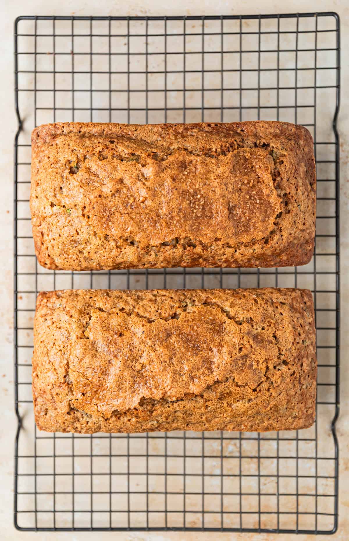 Two loaves of grandma's zucchini bread cooling on wire rack.