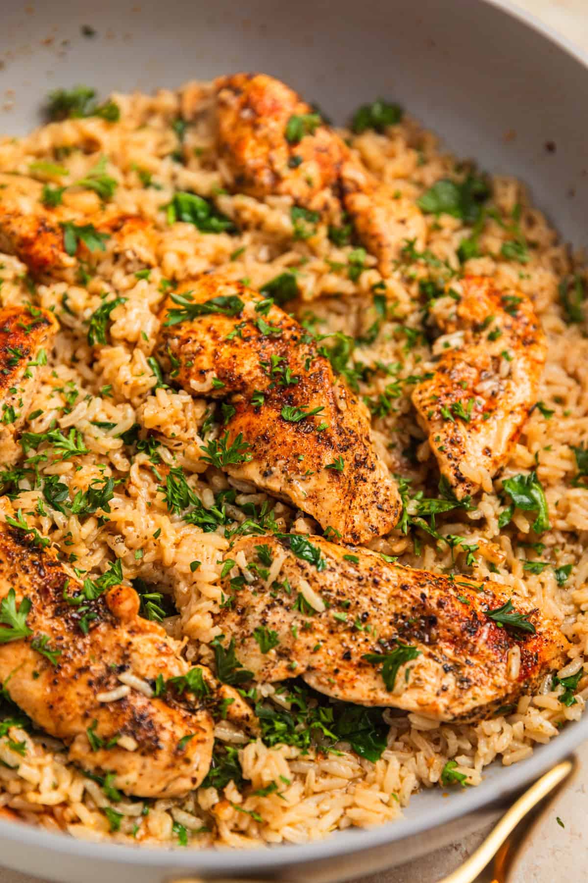 Pan with chicken and rice covered with chopped parsley.
