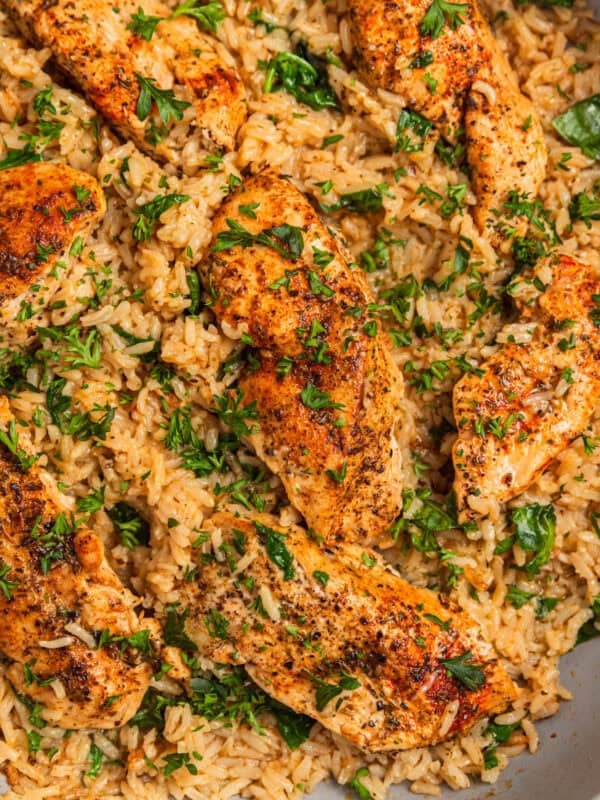 Herbed chicken and rice in pan topped with chopped parsley.