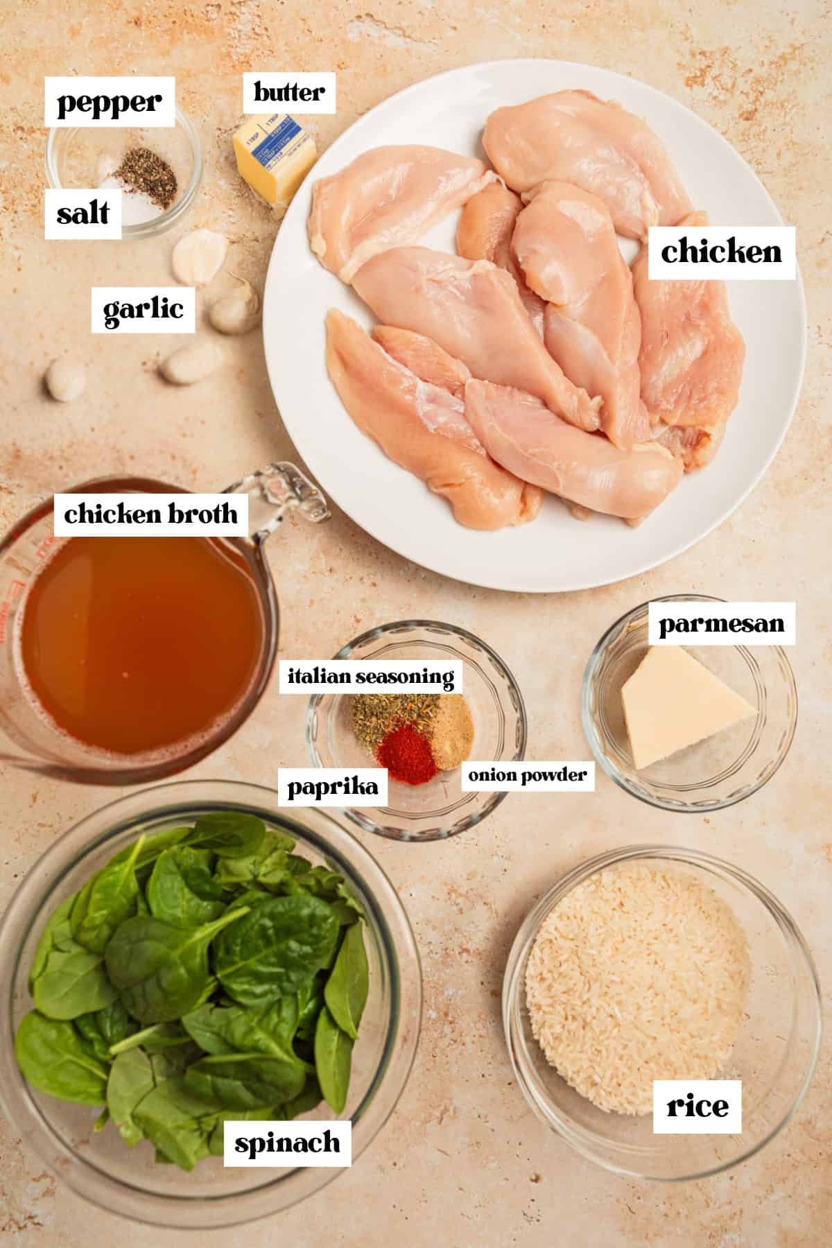 Broth, chicken, spinach and other ingredients on surface needed to make recipe.