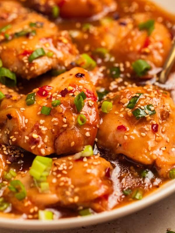 Chicken thighs in apricot sauce with chopped green onions over top.
