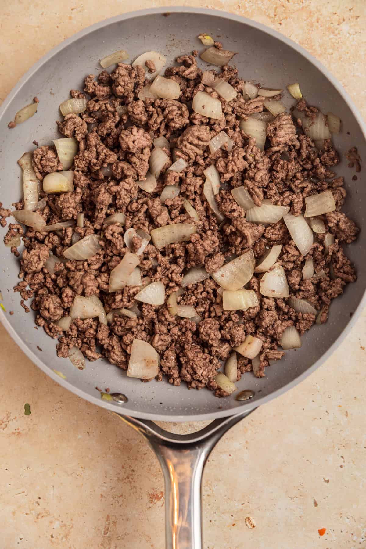 Ground beef and onions browned in skillet.