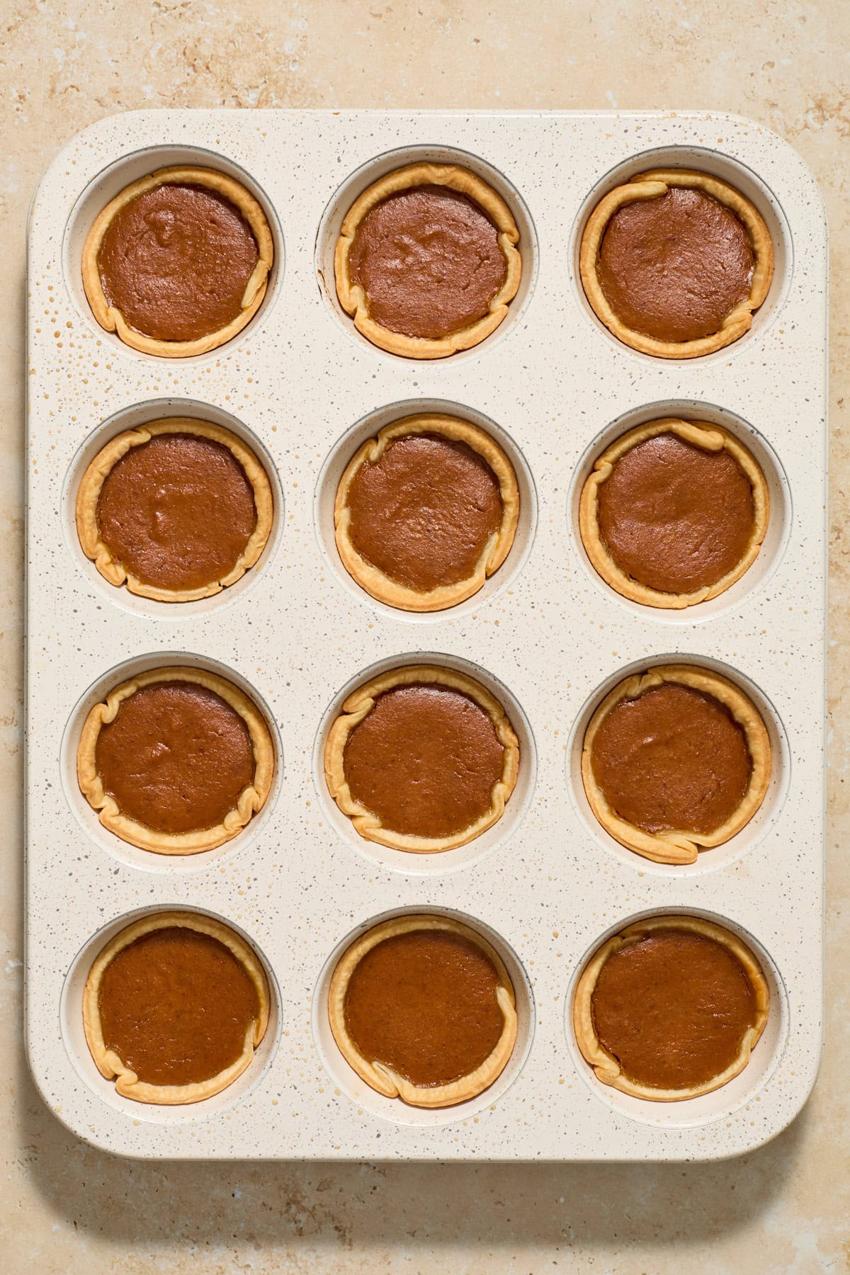 Muffin tin with mini pumpkin pies after baking.