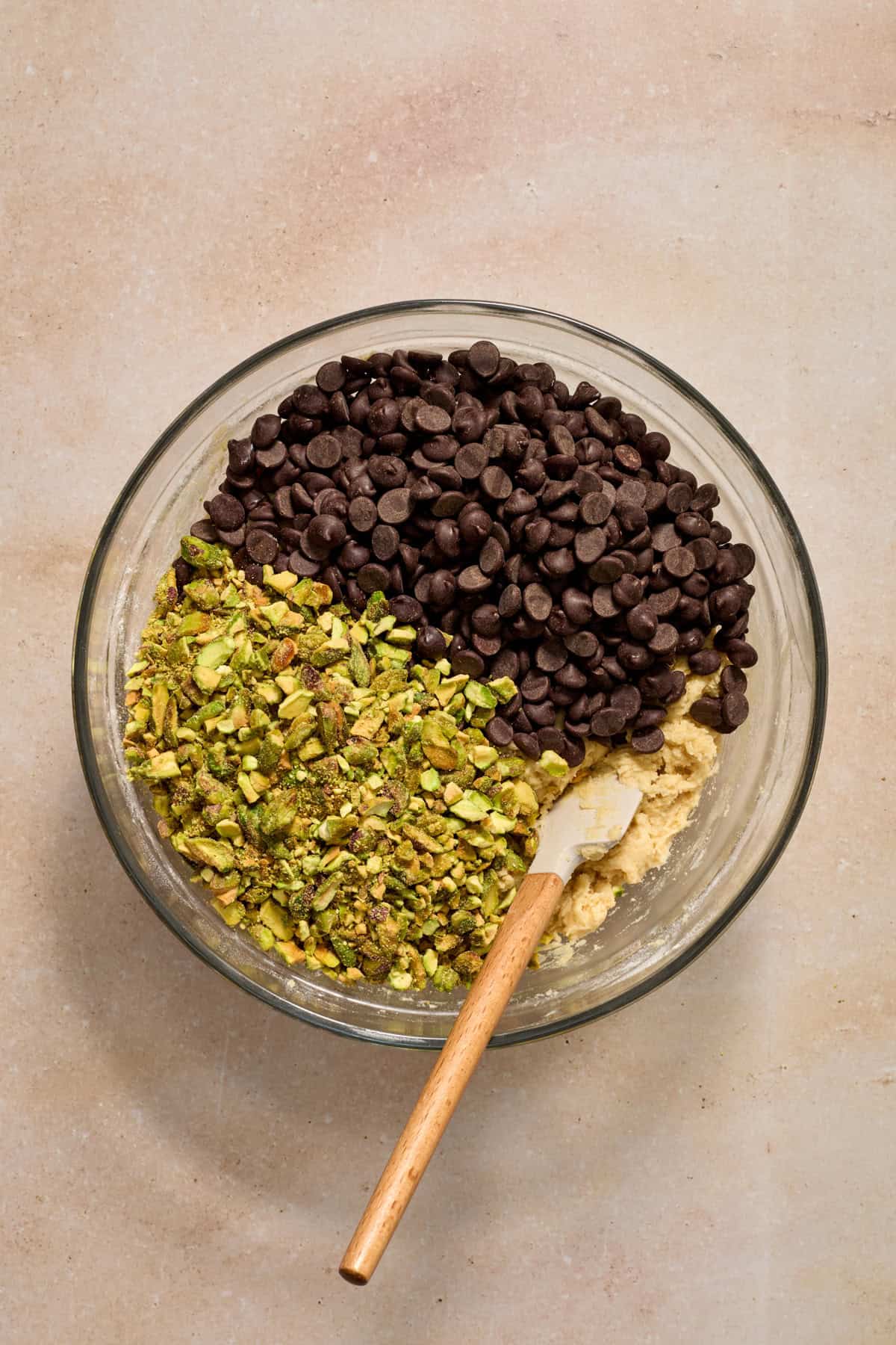 Pistachios and chocolate chips added to bowl with cookie dough.