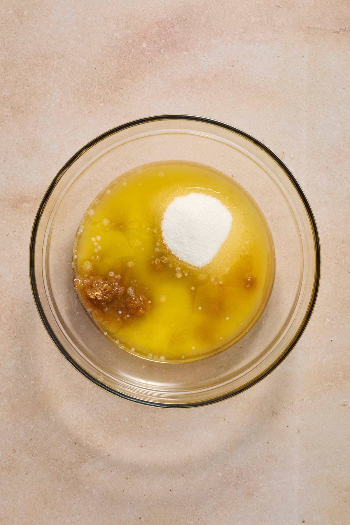 Melted butter, white and brown sugar in glass mixing bowl.