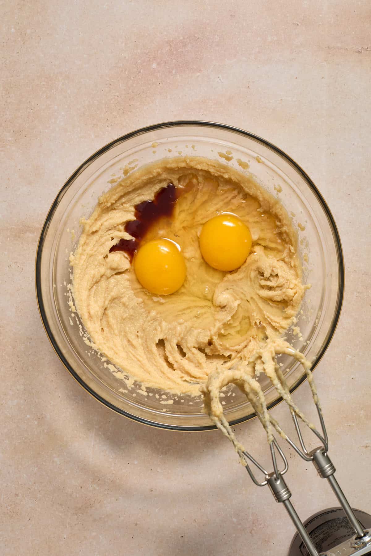 Mixed butter and sugar in bowl with eggs and vanilla added in.