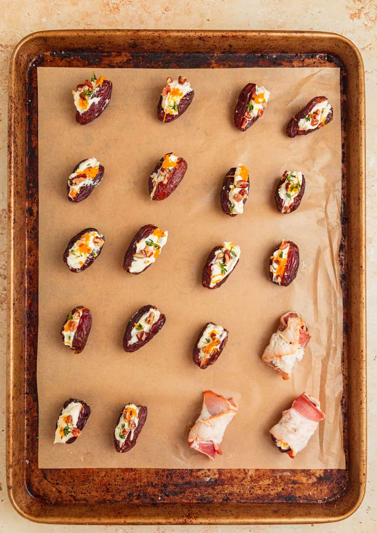 Dates on parchment stuffed with feta, some wrapped in bacon.