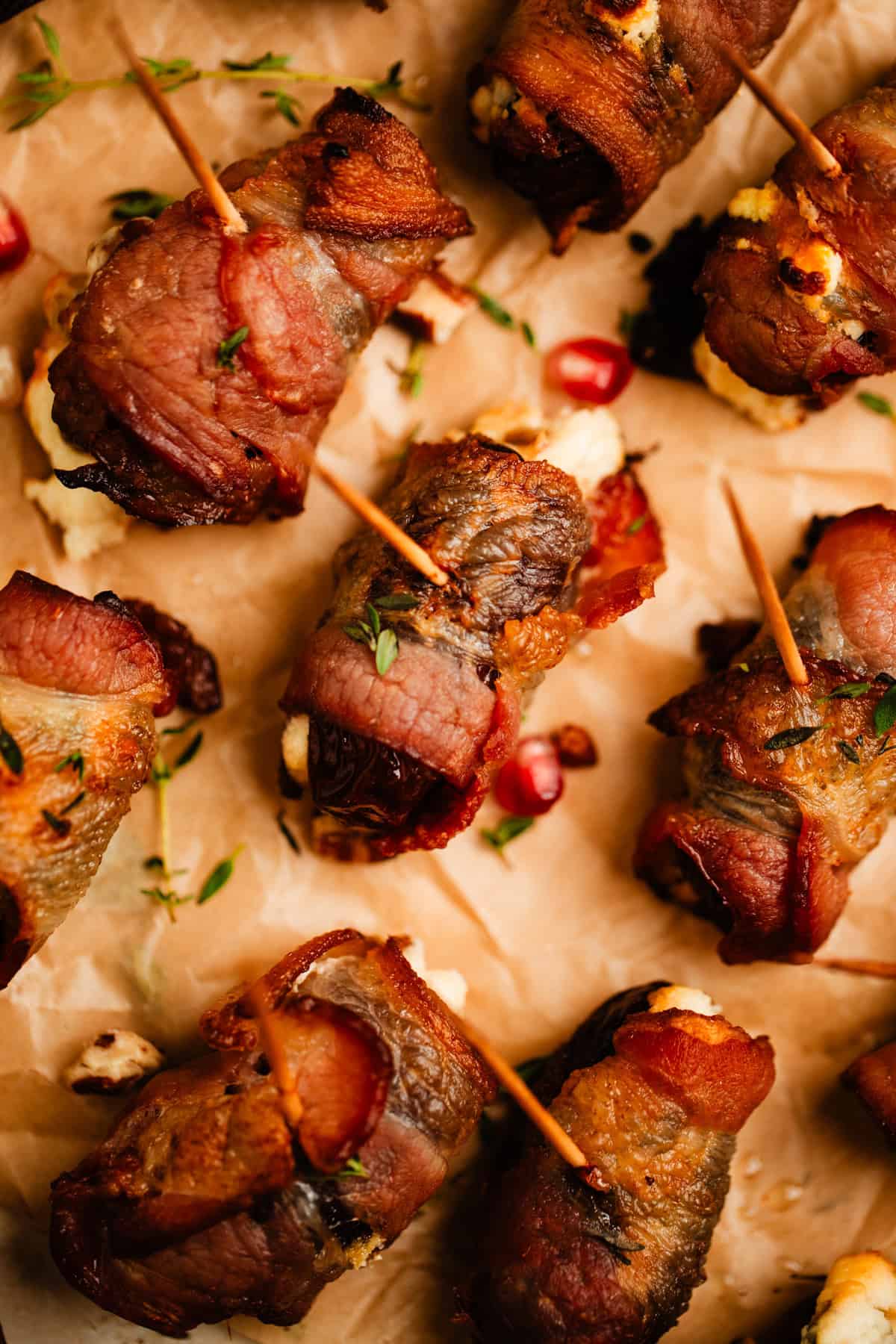 Bacon wrapped dates stuffed with whipped feta on parchment.