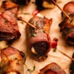 Bacon wrapped dates stuffed with honey whipped feta on parchment.