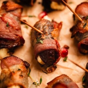 Bacon wrapped dates stuffed with honey whipped feta on parchment.