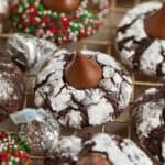 Chocolate crinkle cookies with hershey kiss centers on wire rack.