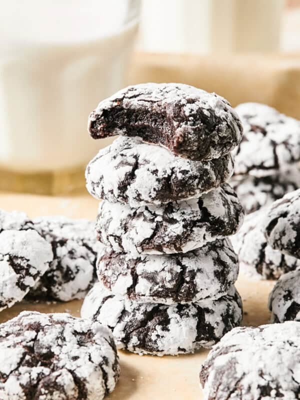 Stack of chocolate crinkle cookies with milk glass.
