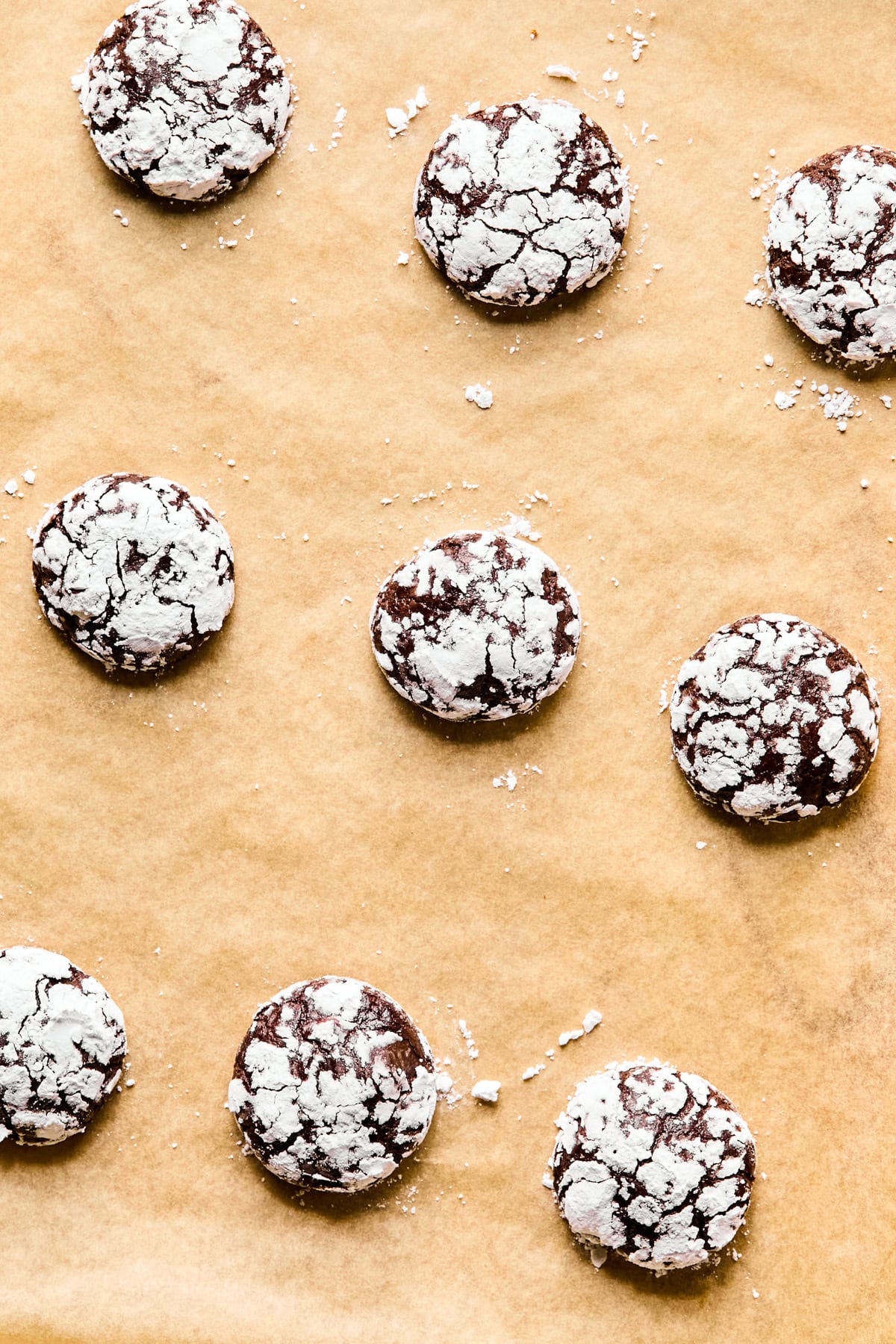 Baked brownie crinkle cookies on parchment.