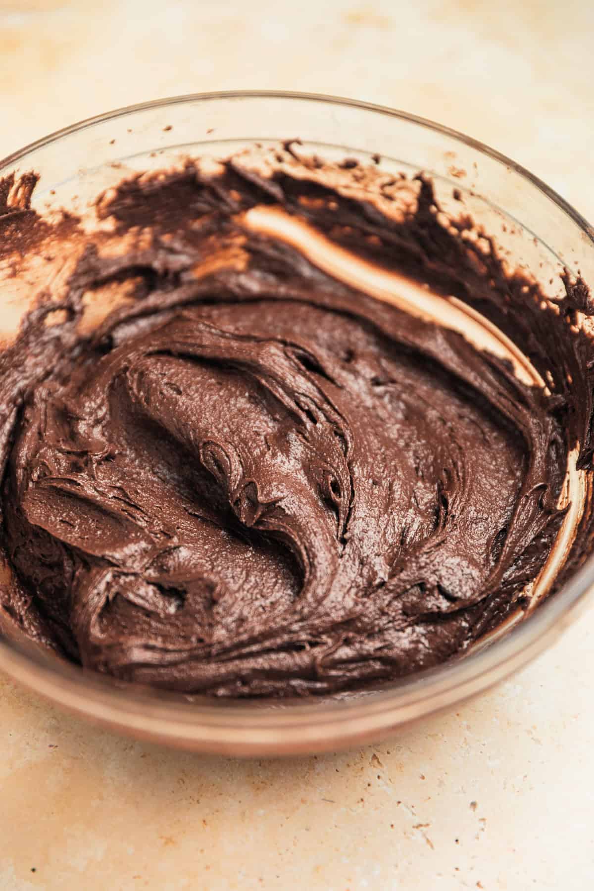 Chocolate cookies dough in glass mixing bowl.