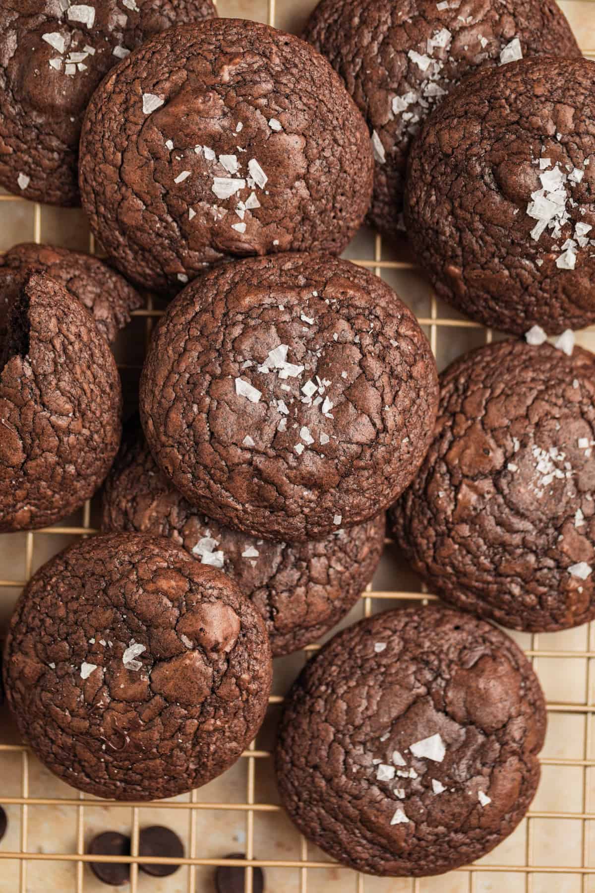 Fudgy cookies with salt on top on wire rack.