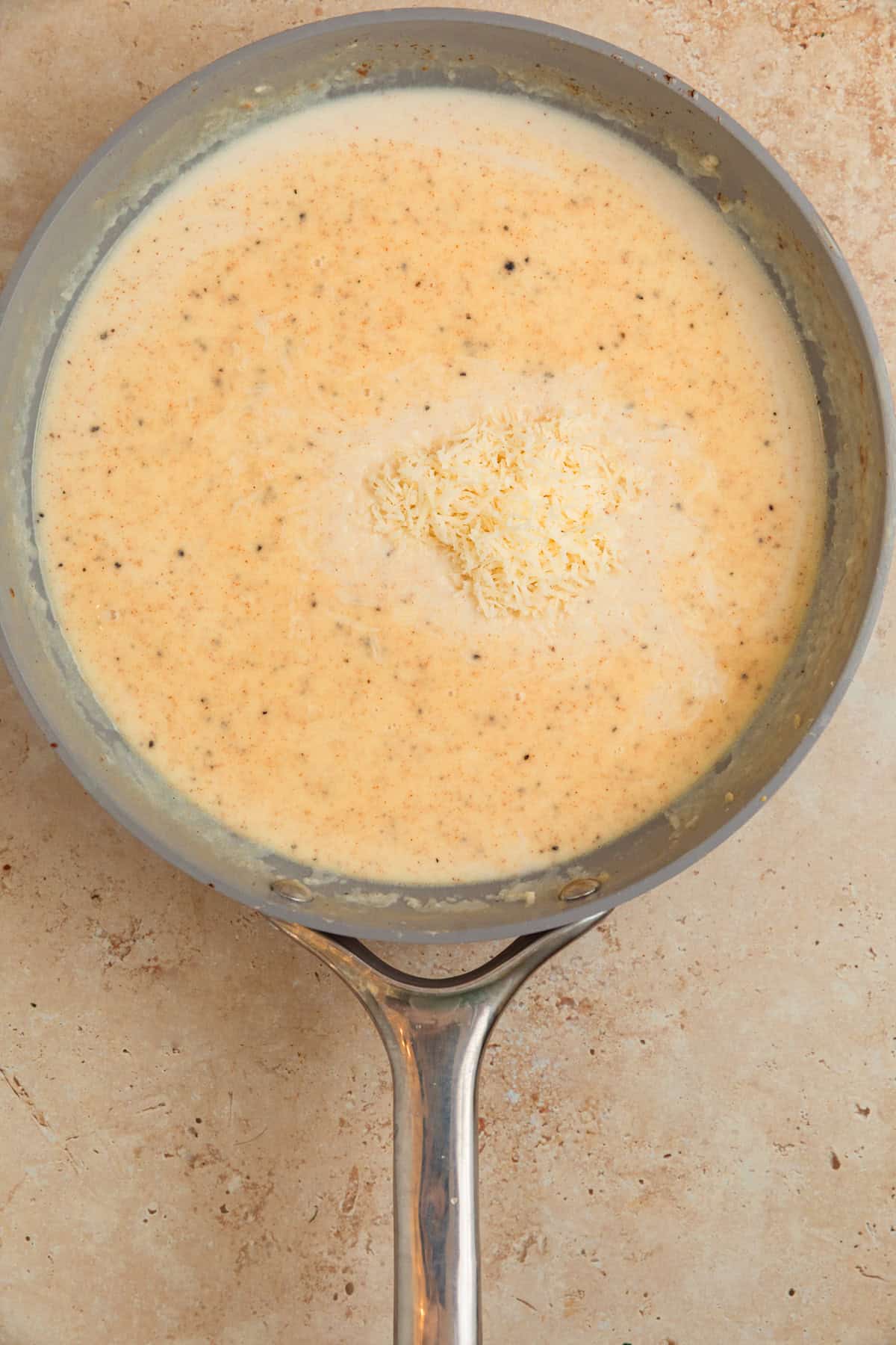 Milk and other ingredients added to skillet with onions.