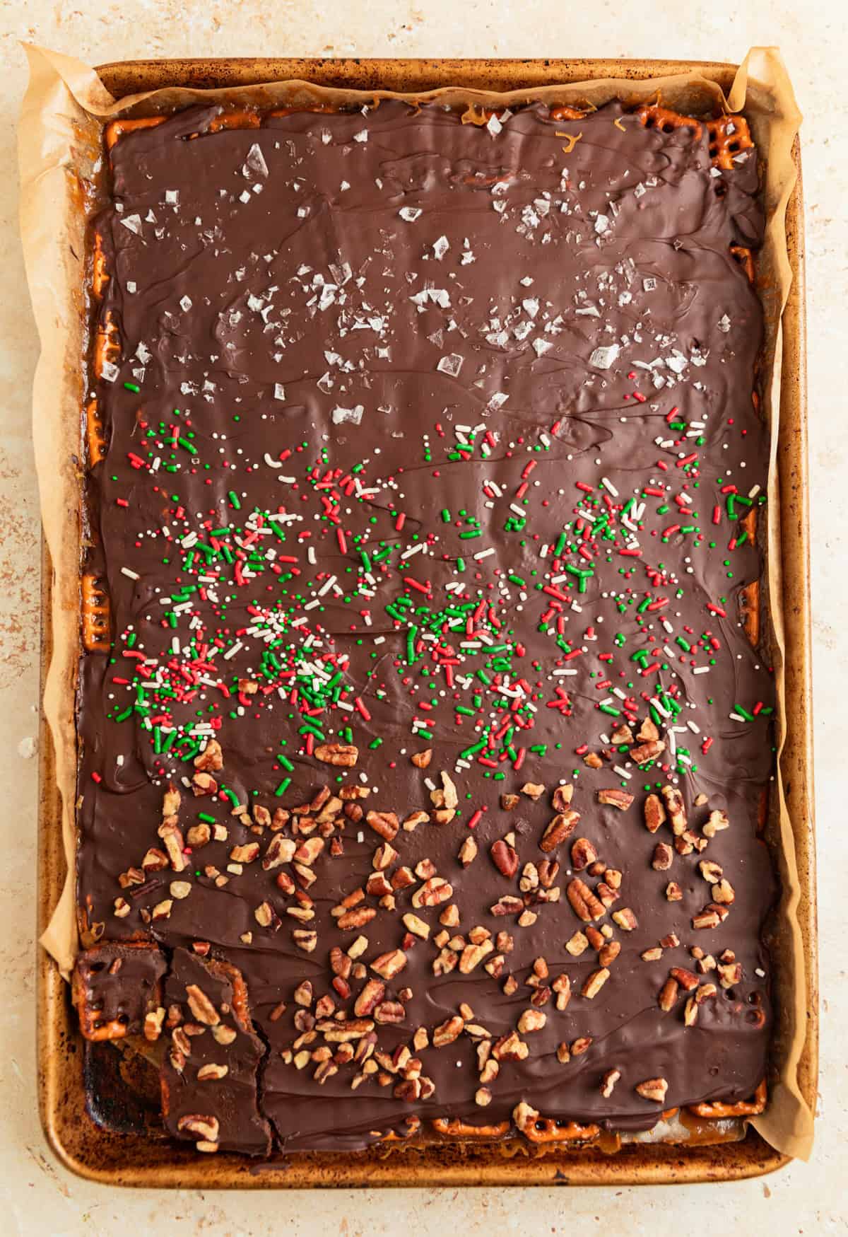Chilled pretzel toffee with pecans, sea salt and red and green sprinkles over top.