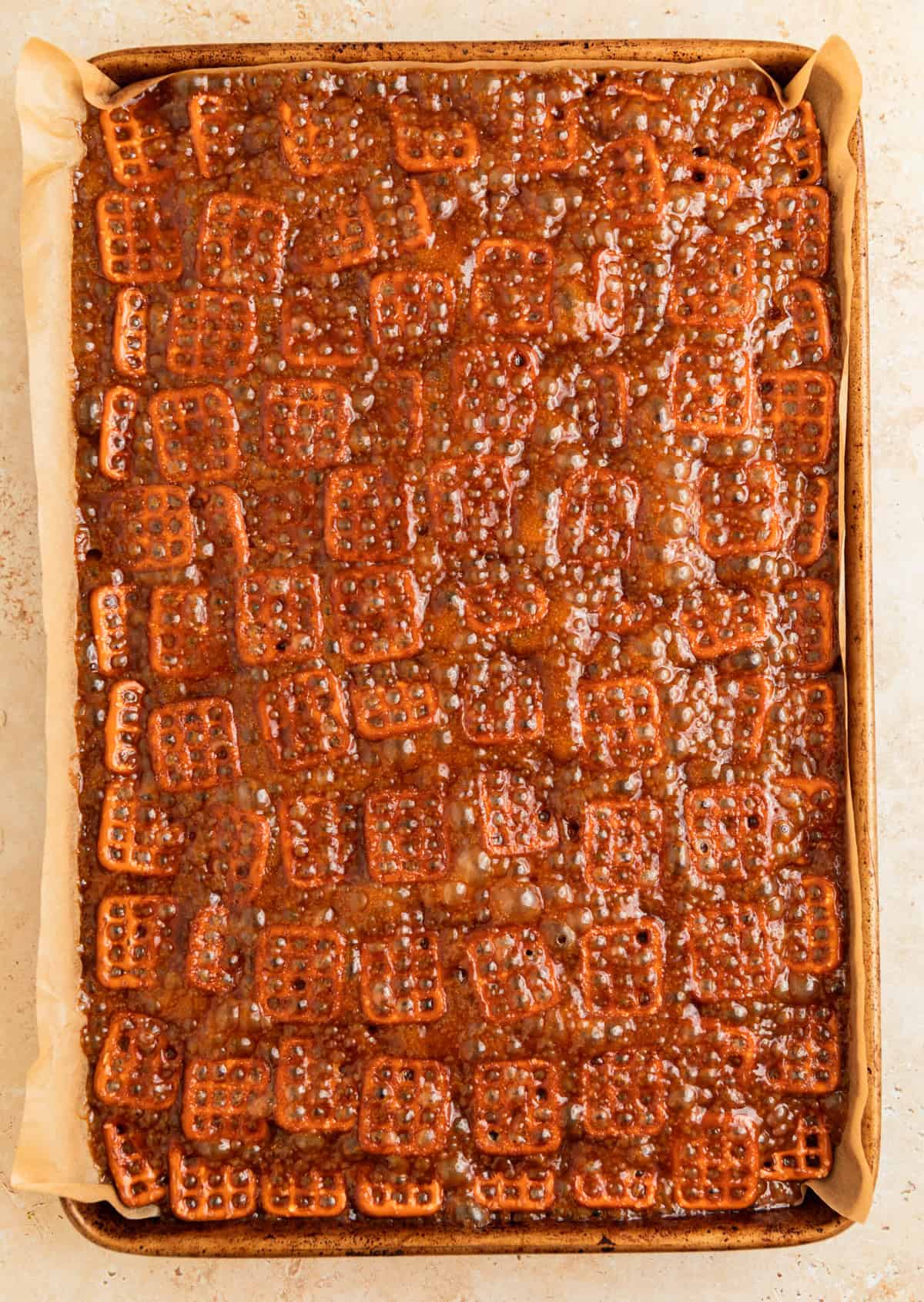 Bubbling caramel on top of lined pretzels.