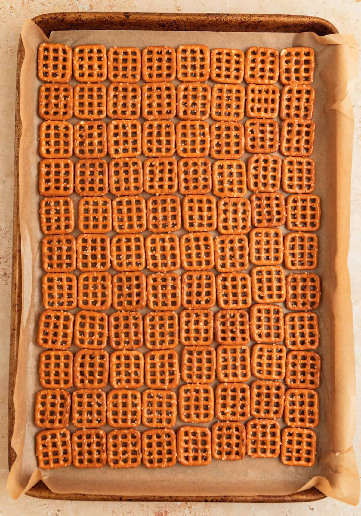 Pretzels lined up to make a grid on parchment lined sheet pan.