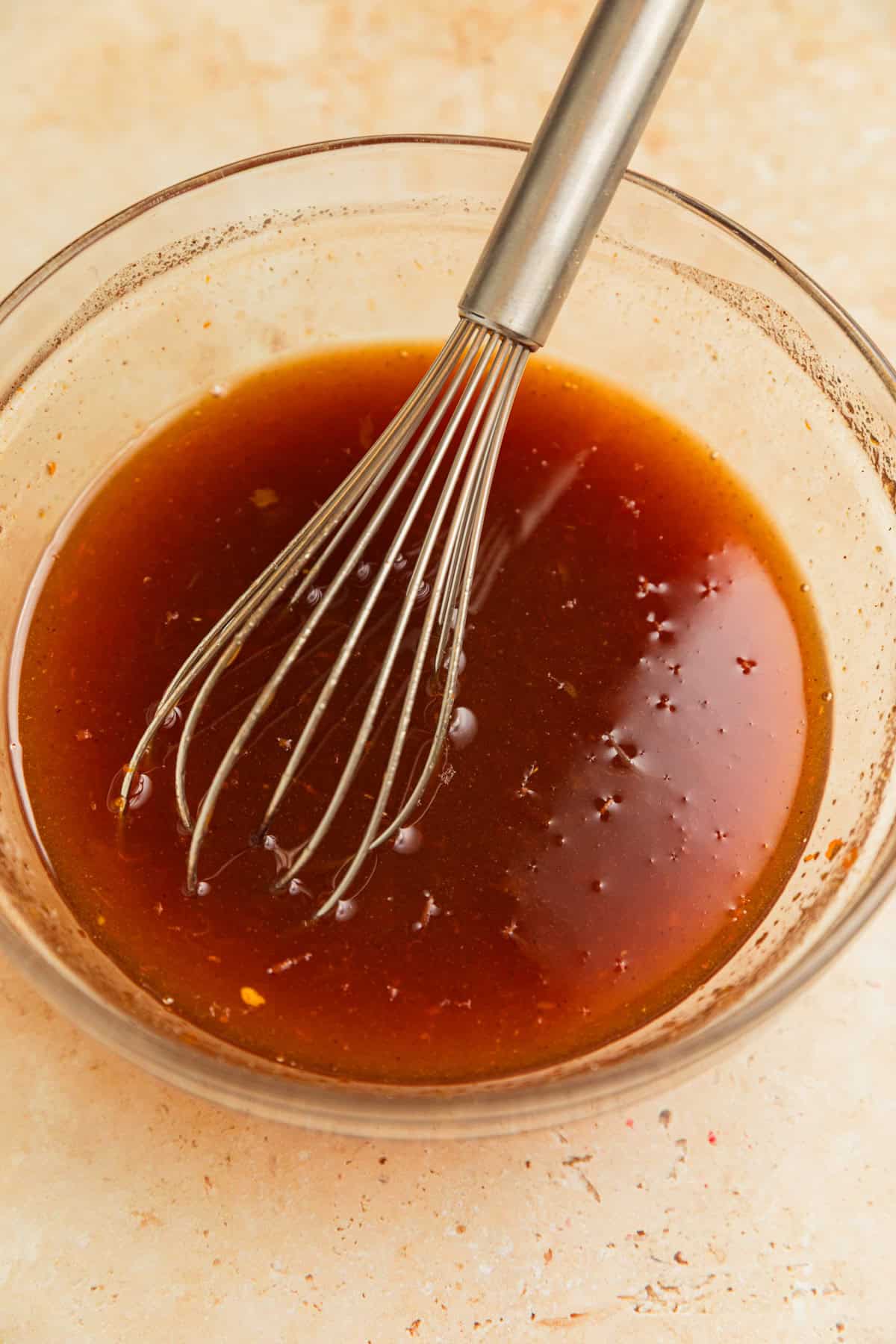 Apricot glaze in bowl with whisk.