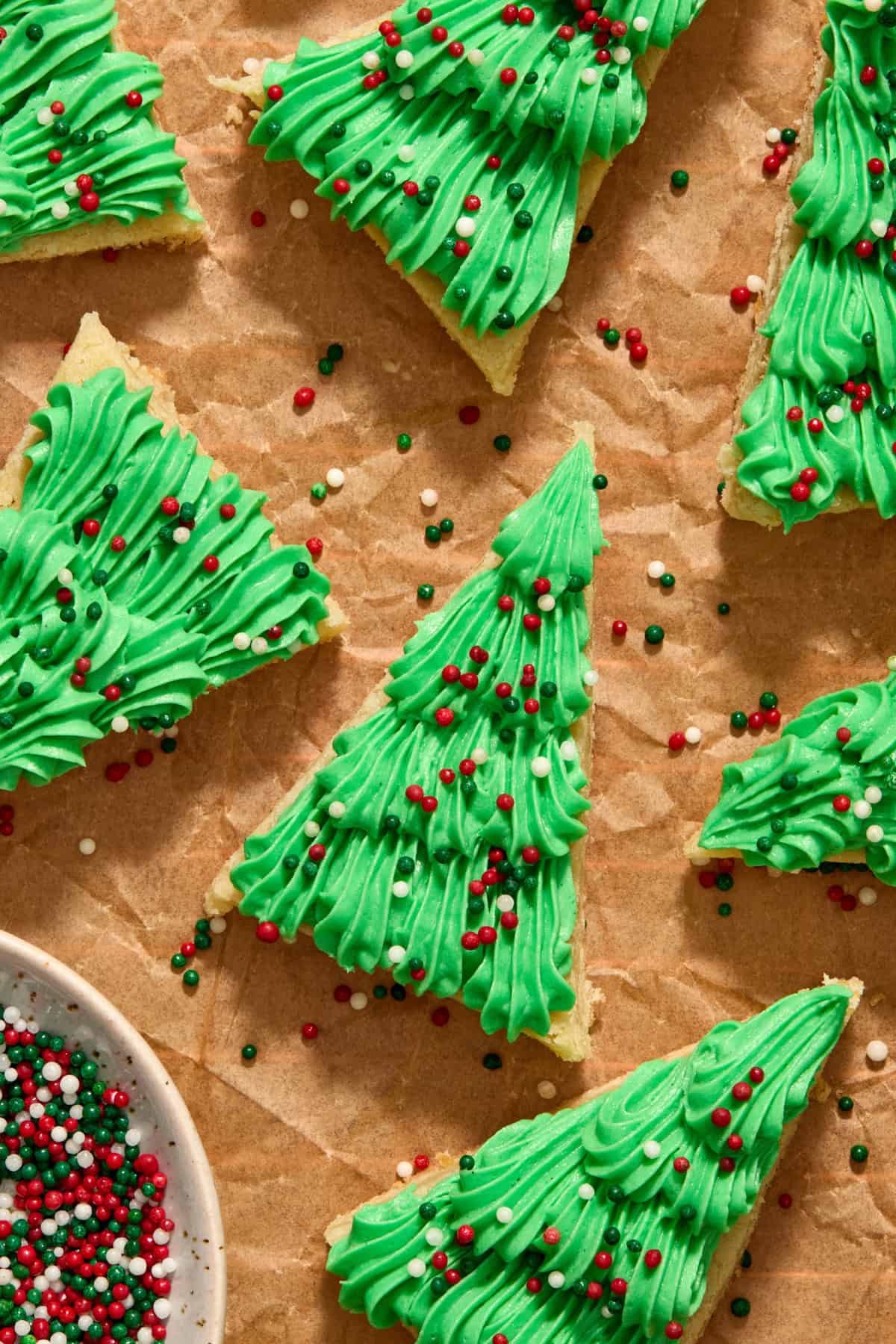 Christmas sugar cookie bars iced with green frosting piped on with sprinkles.