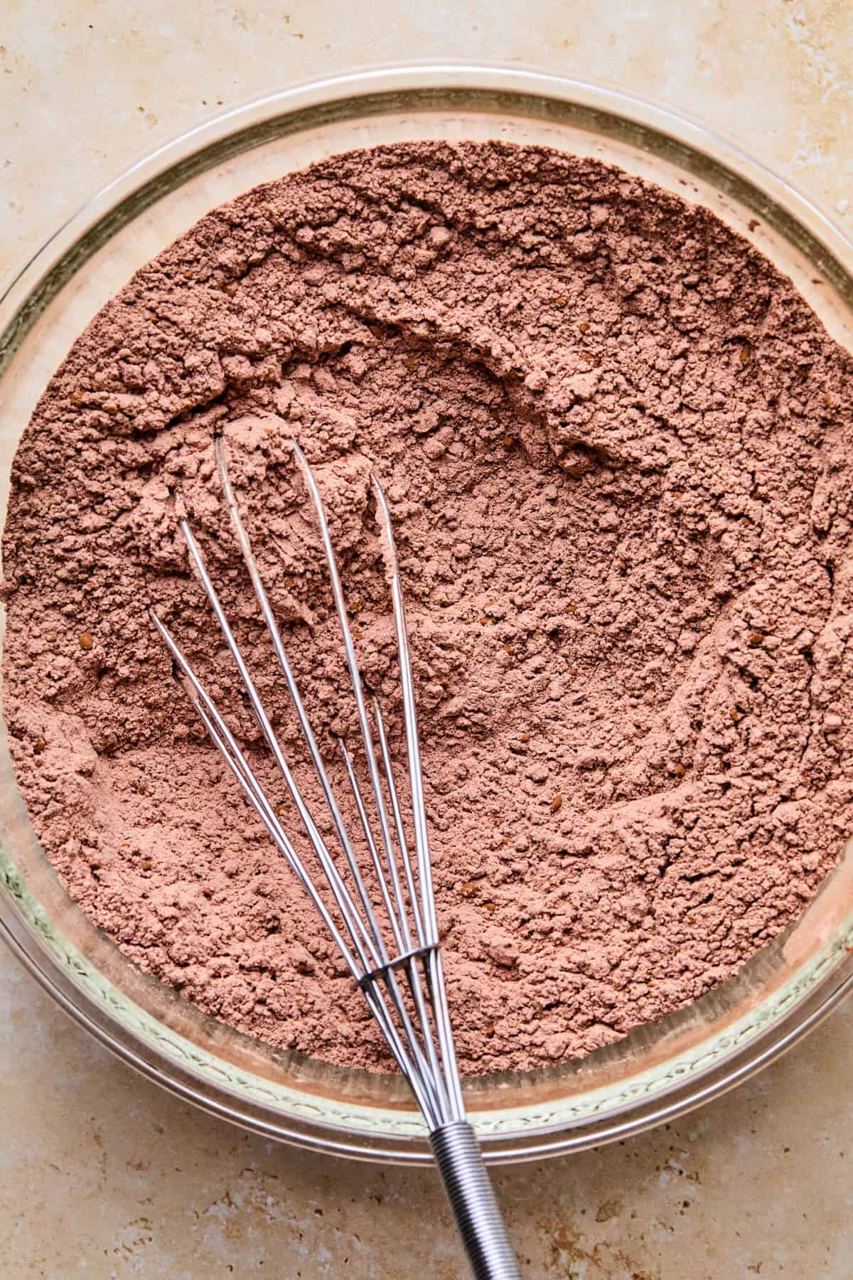 Mixing bowl with whisk and dry ingredients mixed together.
