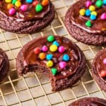 Cosmic brownie cookies on wire rack with bite taken out.