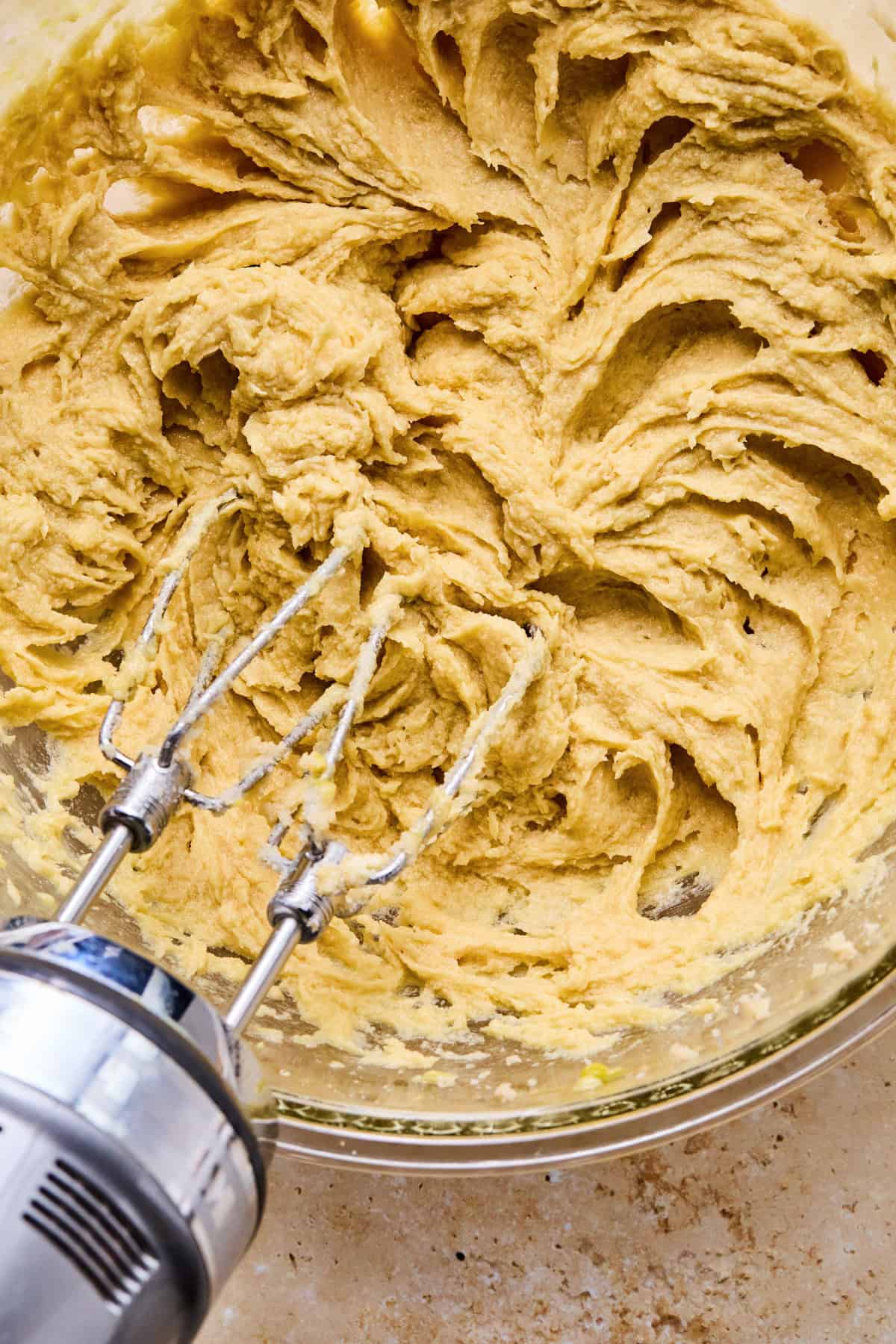 Beaten butter, sugar and eggs in glass bowl.