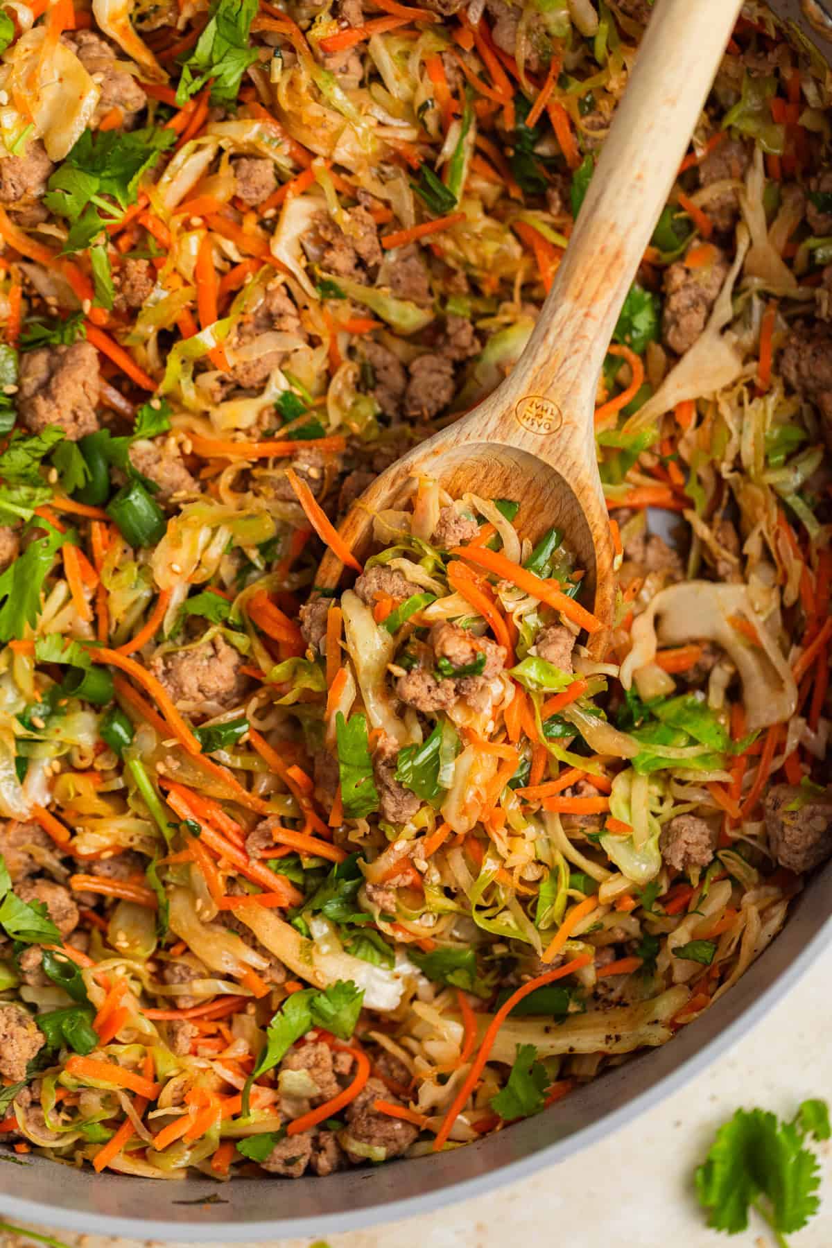 Ground turkey egg roll bowl in pot with wooden spoon.