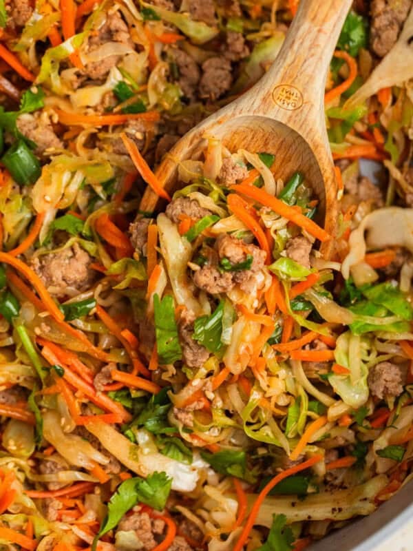 Pot with egg roll bowl made with ground turkey with wooden spoon propped in it.