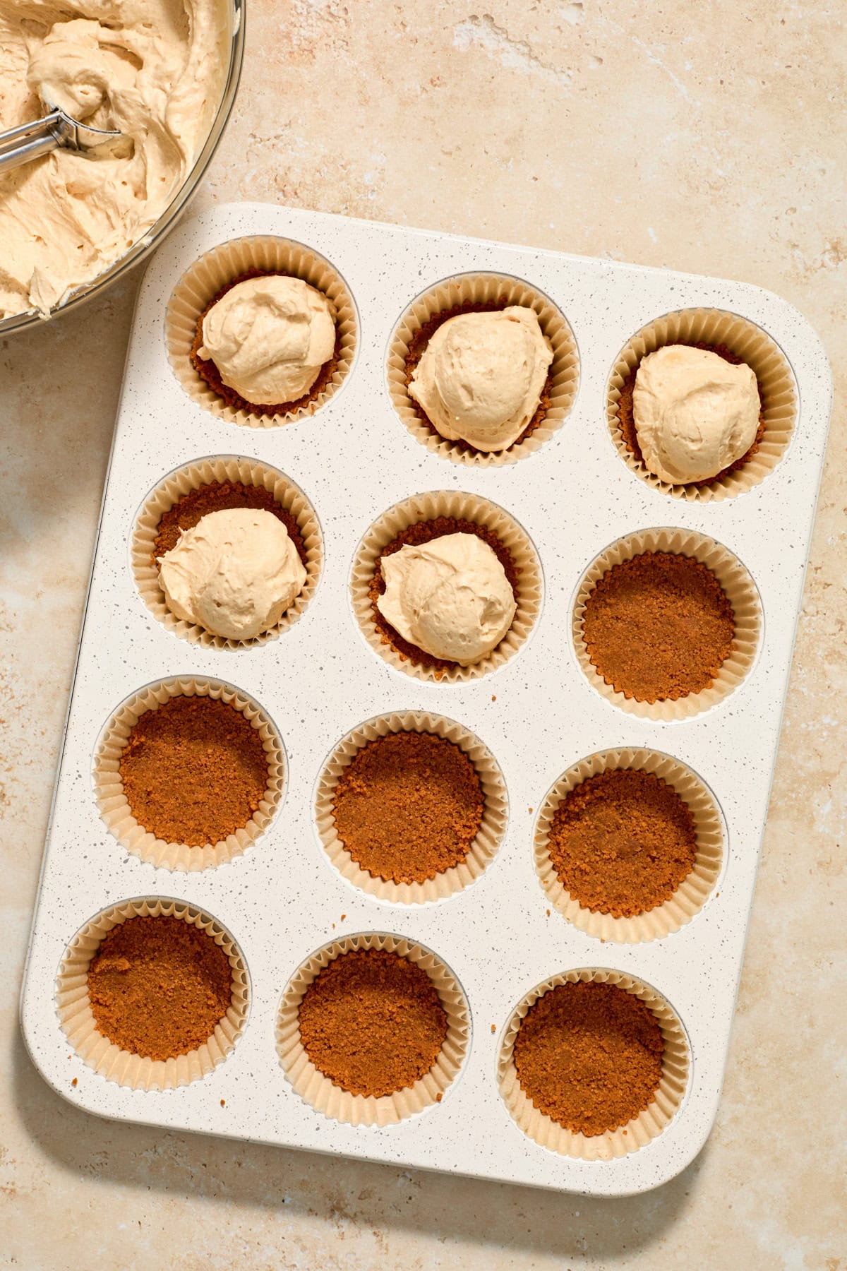 Cheesecake added to crust in muffin tin.