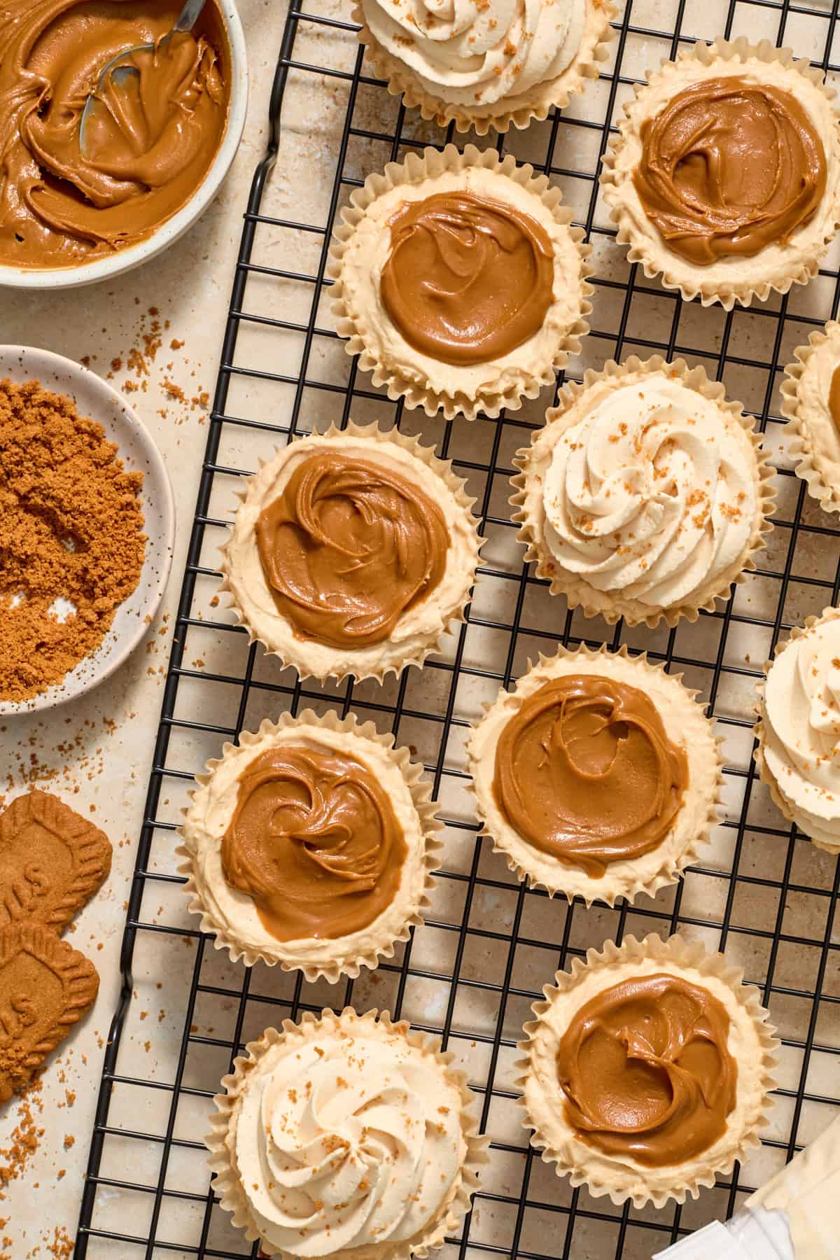 Piped whipped cream on top of mini biscoff cheesecakes.