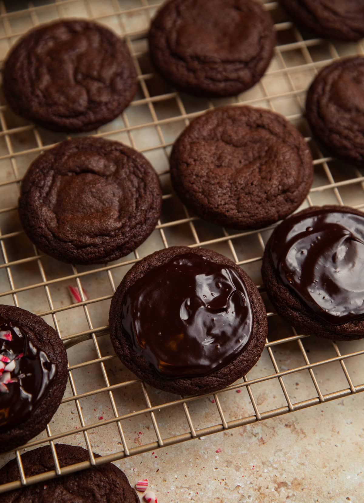 Ganache spread on chocolate peppermint mocha cookies on cooling rack.